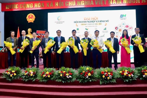 Ban Chấp hành Hội Doanh nghiệp xã Bình Mỹ nhiệm kỳ 2026–2031 nhận hoa trên sân khấu.